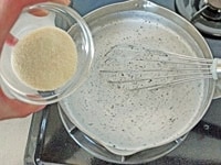 鍋に黒ごま、牛乳、きび砂糖を入れ、中火で混ぜながら沸騰直前まで温めます。粉ゼラチンを加えてよく混ぜます。<br />