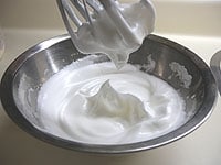 ボウルに卵白を入れます。グラニュー糖を2～3回に分けて加え、きめ細かく、しっかりと角が立つまで泡立てメレンゲをつくります。<br />
