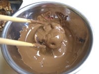 小さいボウルに湯（60度くらい）を入れ、その上に一回り大きなボウルに板チョコとバターを割り入れ溶かします（湯煎）。5を入れ全体をチョコレートでコーティングします。<br />