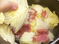 鍋に白菜の1/3量を入れ、その上に豚肉を1/3を入れ、塩1つまみとこしょうをふる。<br />