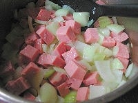 鍋にオリーブ油、にんにく、玉ねぎを入れて火にかけます。にんにくの香りが立ってきたらソーセージを加え、玉ねぎが透き通るまで炒めます。