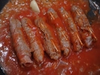 潰したトマトを入れ、弱火にし、フタをして20-30分程煮込む。皿に盛り、イタリアンパセリを飾る。<br />