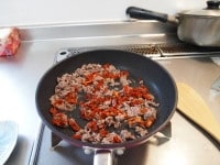 ドライトマトのみじん切りと合いびき肉をフライパンで炒める<br />