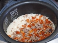 といだ米2合に分量の水を入れて、そこにフライパンの中で炒めた材料を入れる。通常通り炊く。<br />