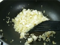 米を加え、オイルとなじむまで炒めます。<br />