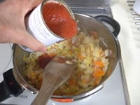 トマト缶、水、固形ブイヨンを加えます。<br />