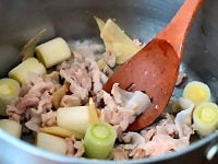 鍋でねぎと生姜、豚肉を炒める