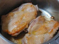 厚手の鍋にオリーブ油の半量とにんにくを入れ、火にかけます。にんにくの香りが立ってきたら下味をつけておいた鶏肉を加え、両面に焼き色がつくまで焼きます。（このとき、中に完全に火が通っていなくても大丈夫です）焼き色が付いたら、いったん取り出します。
