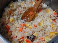 次に、鶏肉を取り出したお鍋（洗わずにそのまま使います）にオリーブ油の残りを入れ、お米と野菜を加えて中火で炒めます。お米が透き通ってくるまで炒めます。