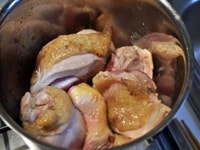 骨付きもも肉はぶつ切りにし、オリーブオイルを敷いた鍋で皮目から焼き、焼き色がついたらヒックリ返し、鍋から取り出す。