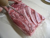 豚ばら肉の全面に、かな串で穴を開けます。<br />