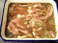 玉ねぎは、炒め用に半分を薄切りにします。タレ用に、もう半分の玉ねぎ、しょうが、キウイをすりおろし、酒と醤油を加えてよく混ぜて漬けダレを作ります。豚肉をタレにまんべんなく漬け込み、室温で20分ぐらい寝かせます。