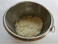 研いだお米をざるにあげ、水気を切ります。<br />