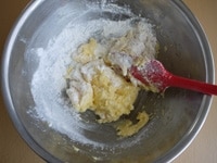 ふるっておいた薄力粉、塩、ベーキングパウダーを2～3回に分けて加え、ゴムべらで切るようによく混ぜます。<br />