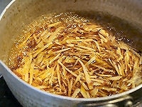 鍋の調味料が沸騰したところへ、かつお節と水気をよく切った生姜を加えます。