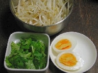 もやしはざっと熱湯に通します。香菜は粗みじん切りにします。ゆで卵は皮をむき、半分に切ります。