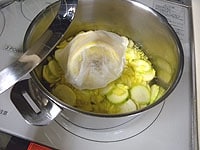 砂糖が溶けて水分が出てきました。レモンが入ったスパイス袋を加え、蓋をします。中火弱で25分ほど柔らかく煮ます。<br />