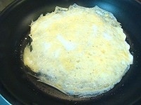 テフロン加工のフライパンに溶き卵を流し込み、「薄焼き卵」を作ります。（必要であれば油を少々敷いてから、卵を流し込む）