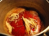 &nbsp;鍋に漬けダレ用の調味料をすべて入れ、火にかけます。沸騰したら火を止め、千切りにした生姜を加えます。