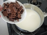 牛乳、粗く刻んだチョコレート、グラニュー糖を鍋に入れ、チョコレートとグラニュー糖がとけるまで、中火で混ぜながら加熱します。<br />