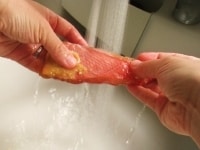 ラップを開き、金目鯛を取り出します。表面についた味噌を流水で洗い水気をふきとっておきます。<br />