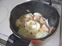 圧力鍋にオリーブオイルを入れ、こしょうだけを振った鶏肉を炒めます。うす切りのたまねぎも炒めます。<br />