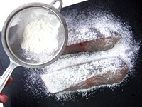 白身魚に塩、こしょうを少々ふり、茶こしを使い、小麦粉を全面にふりかけます。<br />