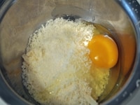 ボウルに、すりおろしたパルメザンチーズ、牛乳、卵を入れて、よくかき混ぜておく。<br />