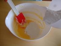 卵が馴染んだら、振っておいた粉とベーキングパウダーを加え混ぜ合わせ、そこに牛乳を加えて混ぜます。<br />
<br />