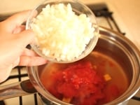 鍋に、水、ブイヨン、カットトマトを入れて、さらに、玉ねぎ、セロリ、ピーマン、さくらえびを入れて、火にかけて沸騰させます。<br />