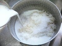 鍋に、ご飯、牛乳、砂糖、バニラエッセンスを入れ中火にかける。 <br />