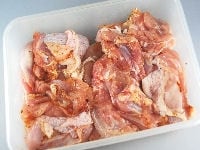 鶏モモ肉は、4つぐらいのぶつ切りにし、ケイジャンミックススパイスの半分の量と塩（分量外：2つまみ）をまぶしてもみこんで下味をつけます。