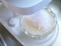 (4)で作った桃のソースの半量を器に敷き、氷を削り入れる。 <br />