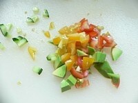 トマトピクルス、きゅうり、アボガドを5mm角に刻んで混ぜる。玉ねぎは薄くスライスして水にさらして軽くもんで、水気を切っておく。<br />