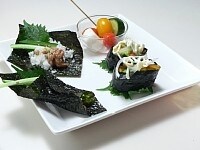 板海苔を4つに切り、寿司飯、わさび、大葉、納豆、細切りきゅうりをのせ、白ゴマをかける。<br />
