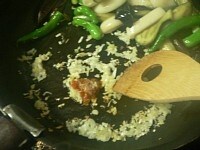 フライパンの手前をあけ、油を少し足してニンニク、生姜、ねぎを炒める。香りが立ったら豆板醤を入れて炒める。<br />