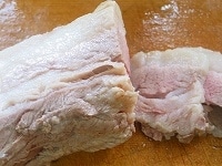 茹でた豚バラ肉を薄切りにします。