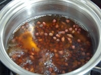 小鍋に3カップの水と小豆を入れて沸騰させます。沸騰したら弱火にして20～30分、小豆の芯が残るくらいの柔らかさになるまでゆでます。途中、ゆで汁が半分くらいまで減るようなら、水を足してください。<br />
<br />
<br />