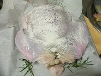天板に、くず野菜を敷いて、鶏をのせ、オリーブオイルをかけ、250℃に予熱したオーブンに入れる。 <br />