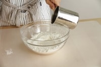 ラードが粒状になったら、粉の中心にくぼみをつくり、そこに熱湯を注ぐ。<br />