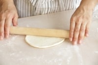 表面にもう一度、打ち粉をして、麺棒で厚さ2～3ミリの円形に伸ばす。<br />