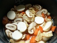里芋、にんじん、椎茸、油揚げを入れる。具の部分を軽く混ぜて炊く。<br />