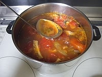 次にトマトの水煮缶と豆缶を加え、弱火で1時間ほど煮ます。途中あくが出てきたら取り除きます。<br />