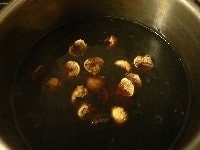 黒豆を食べてみて、硬いながらも食べられるほどになってるのを確認し、イチジクとプルーンを加える。水が少なくなっていたらイチジクが隠れる位まで水を足し、再び蓋をして弱火で30分ほど煮る。 <br />
<br />