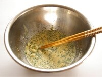 卵を割りほぐし、牛乳、チーズ、パセリ、ブラックペッパーを入れて、よく混ぜ合わせ、食パンを加えて、さらに混ぜ、しっかりと浸します。<br />