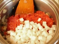 にんじん、大根、トマトのホール缶、水、ブイヨン、オレガノを入れて、塩こしょうをし、全体を混ぜたら蓋をして8分煮ます。<br />