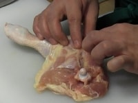 骨の周囲の肉を指でしごいて骨が見えるようにし、関節を包丁で切る。