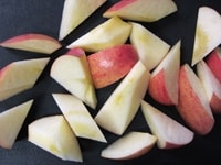りんごは8～10等分のくし形に切り、芯を切り落としたら、一口大の斜め切りにします。