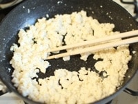 フライパンに水切りをした木綿豆腐を入れて、菜箸でほぐしながら炒めます。
