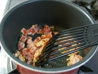 鍋にごま油を熱し、豆板醤を加えて炒めます。香りが出たら、豚肉も入れて色が変わるまで炒めます。
